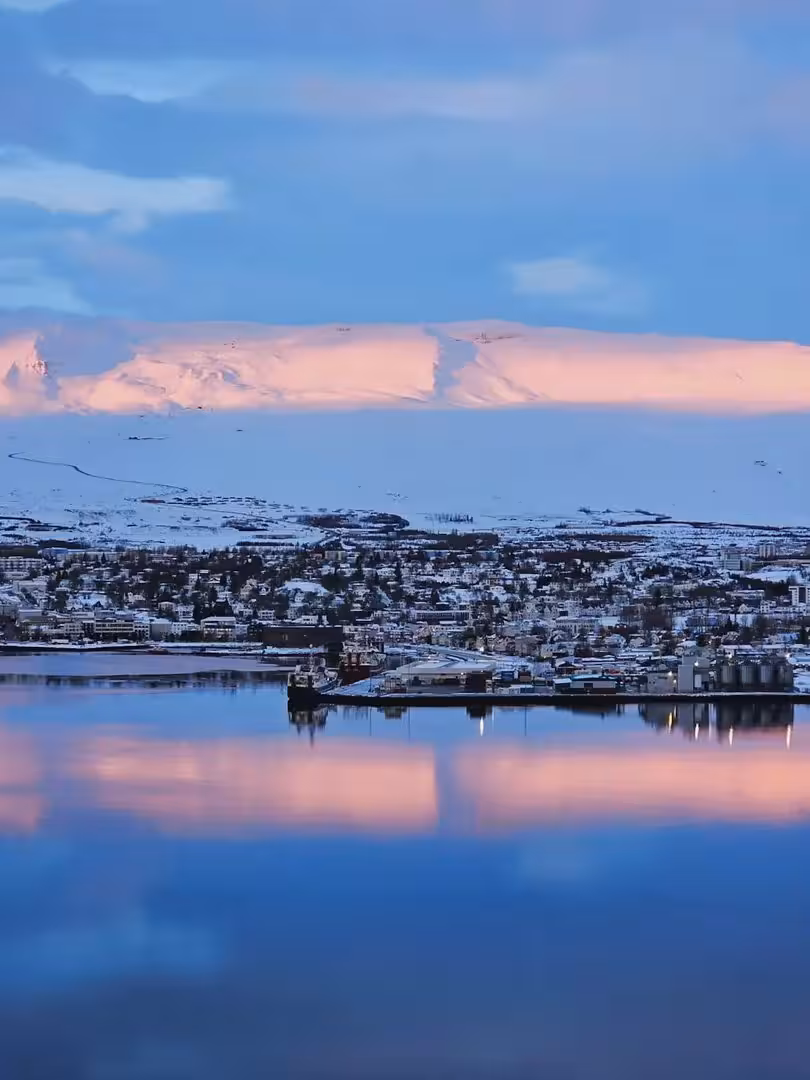 Reykjavik winter skyline reflected in calm water at dusk, part of a private Iceland holiday magic tour