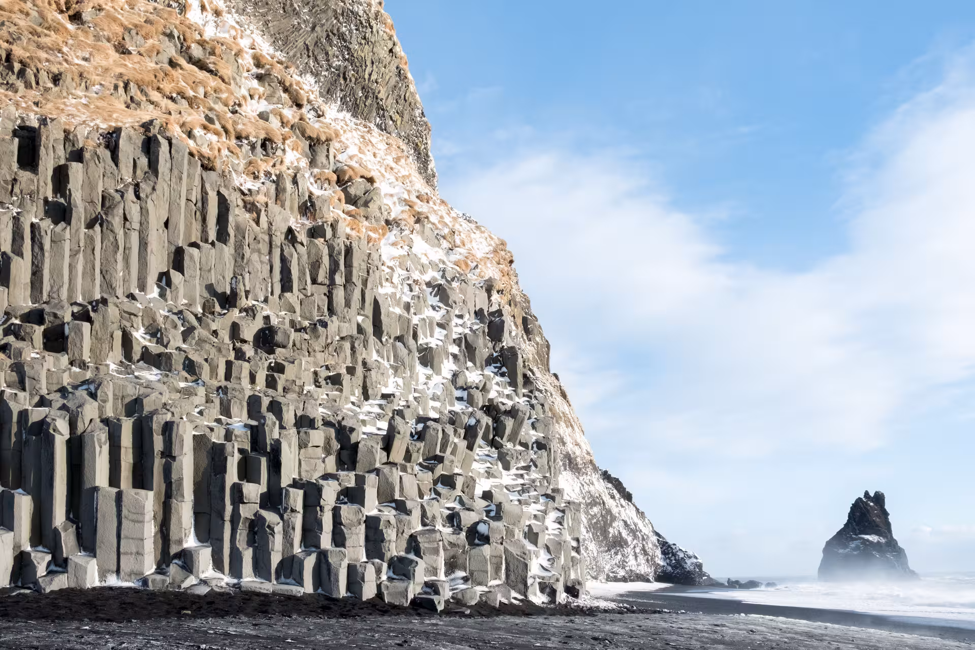 Majestic basalt columns at Reynisfjara Beach, Iceland under clear skies, a highlight of the 5-day stopover tour.