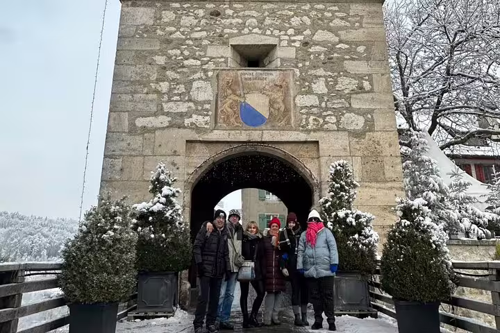 Group of tourists at Stein am Rhein's stone archway, experiencing Swiss history on a private day trip from Zurich.