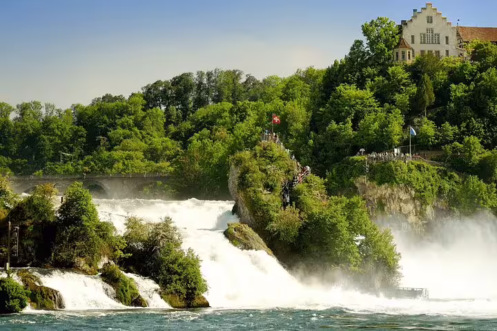 Lush green landscape and cascading Rhine Falls viewed from Stein am Rhein, a highlight of Zurich private tours.