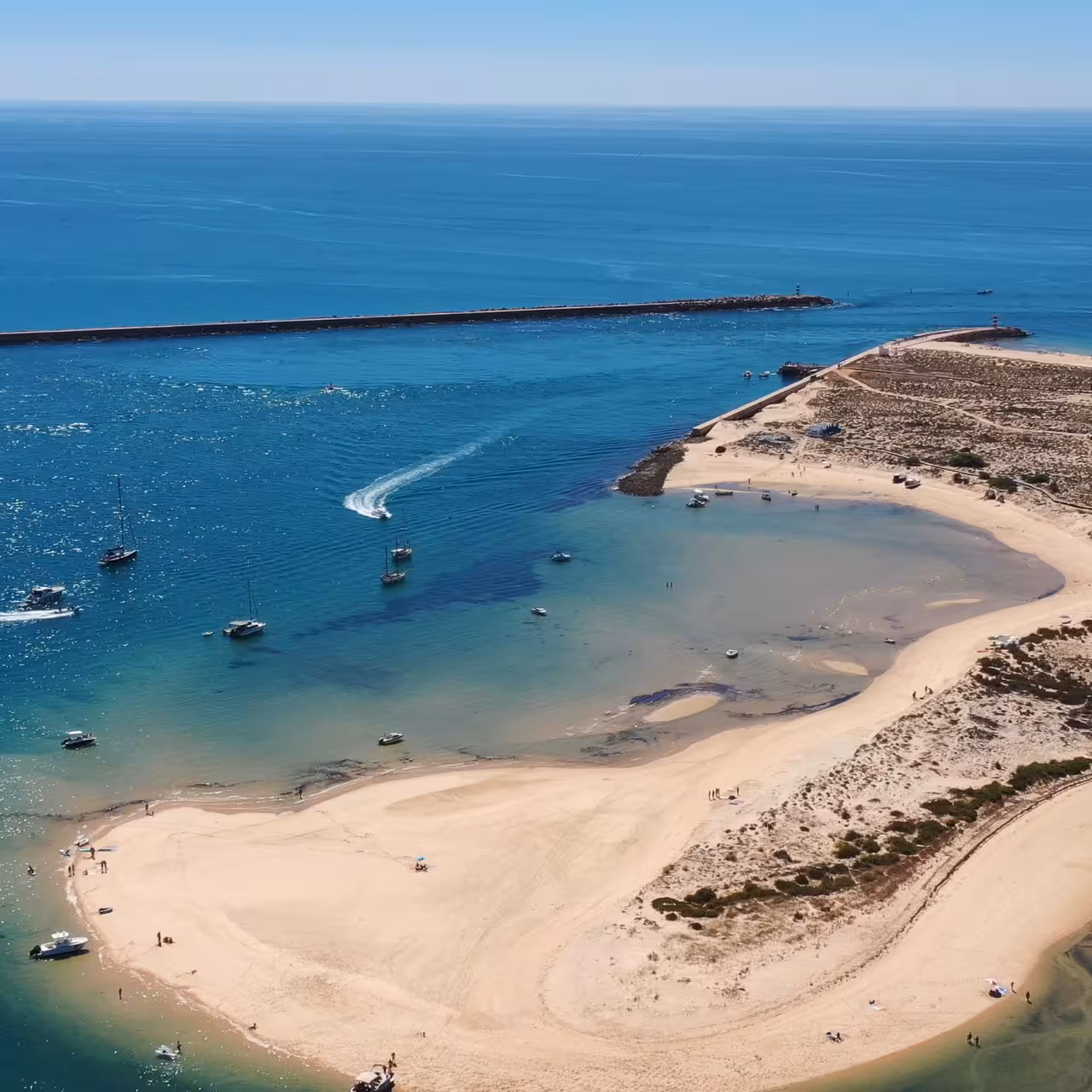 Aerial view of Ria Formosa sandbar and turquoise lagoon with boats, featured on 2-hour boat tour