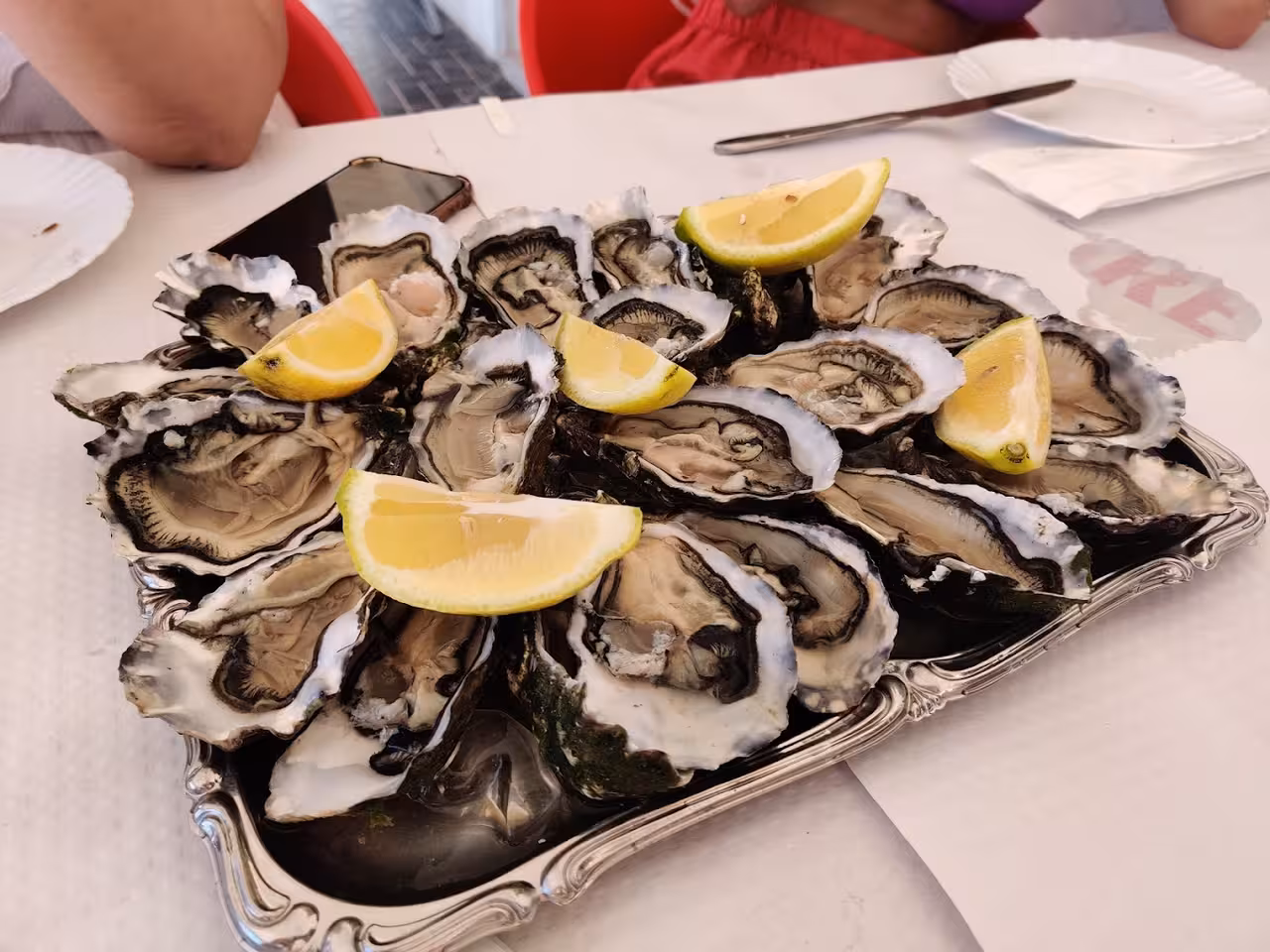 Fresh Algarve oysters with lemon served on a platter, a tasty stop on the Ria Formosa 3-island full-day tour