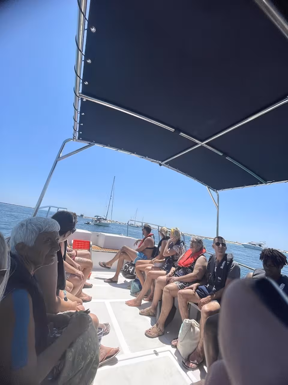 Guests relax on a covered speedboat during a 2-hour Ria Formosa tour, cruising Algarve lagoon waters