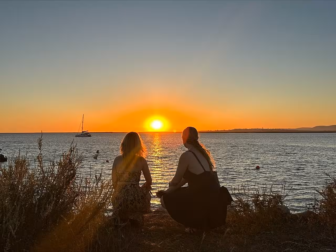 Sunset over Ria Formosa lagoon with sailboat, perfect moment on a 3-island full-day boat tour from Faro