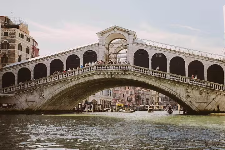 Scenic view of Rialto Bridge over the Grand Canal, showcasing Venice's historic architecture and vibrant waterways.