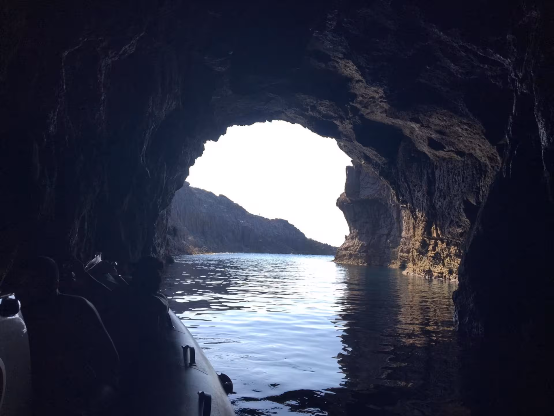 Exploring a stunning sea cave with a RIB boat on the Sant'Antioco to Carloforte tour, featuring rugged rock formations.