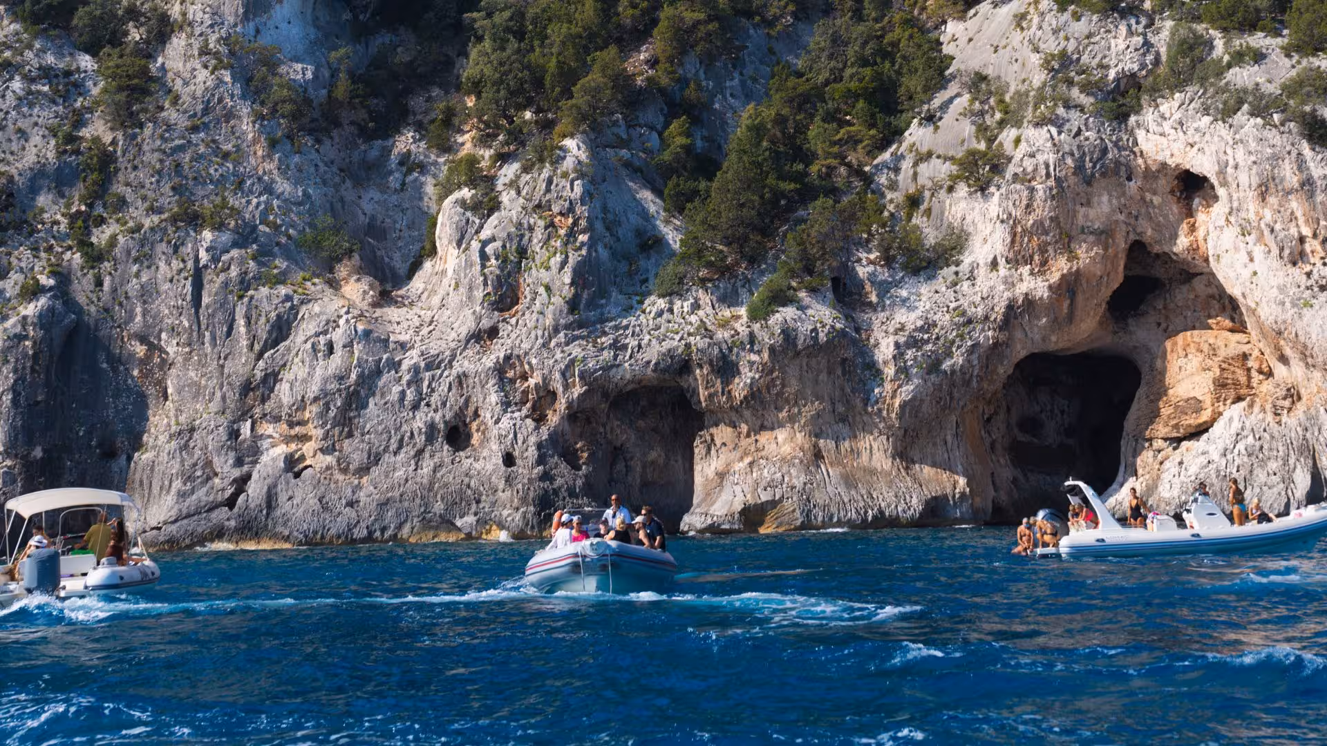 RIB boats exploring sea caves along the rugged coastline between Cala Luna and Cala Goloritzé on a scenic tour.