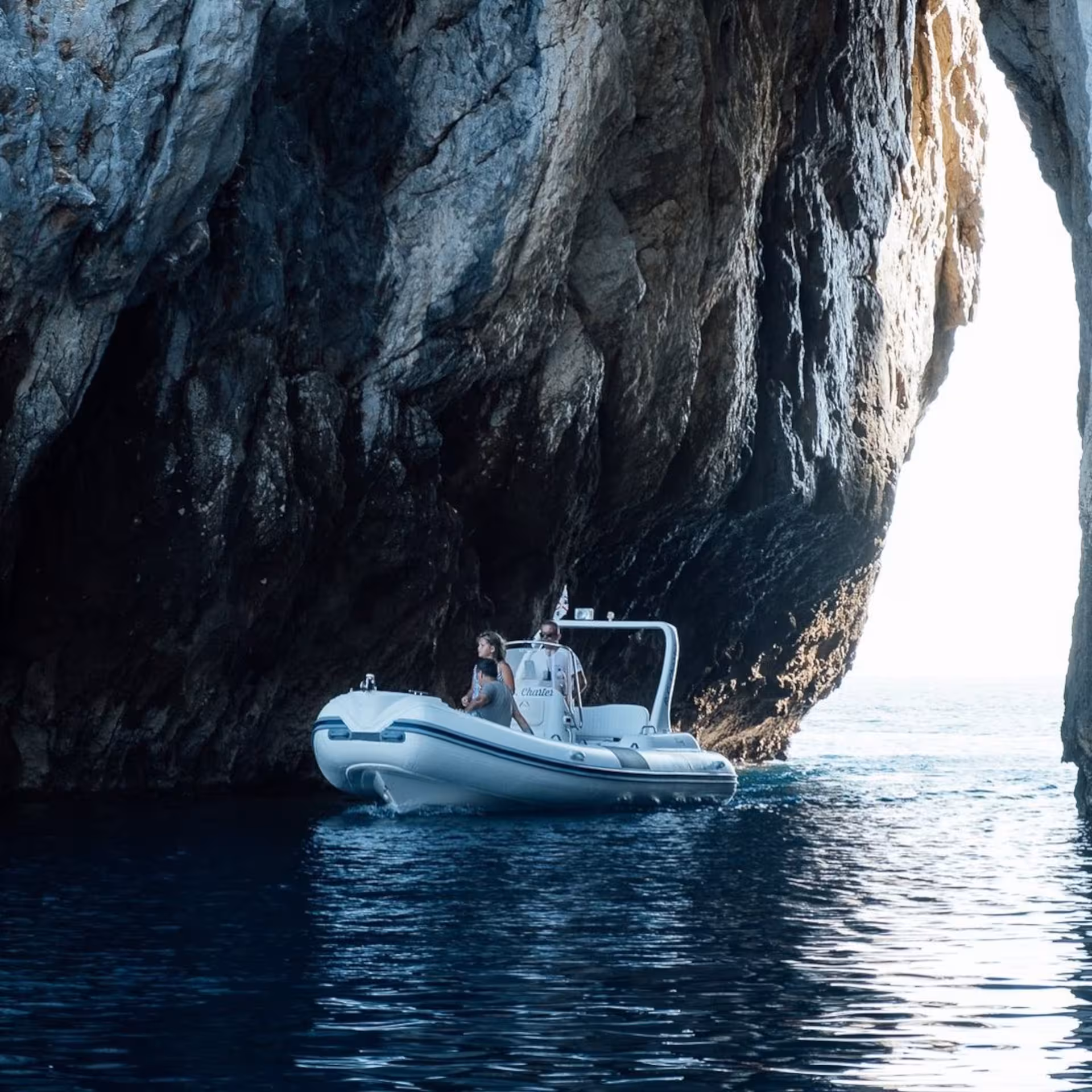 RIB navigating through a dramatic sea cave on the Carloforte to Masua tour.