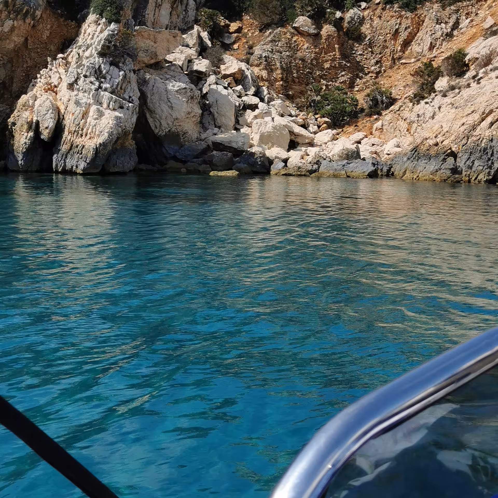 Turquoise waters and rugged coastline on a RIB tour from Sant'Antioco to Carloforte.