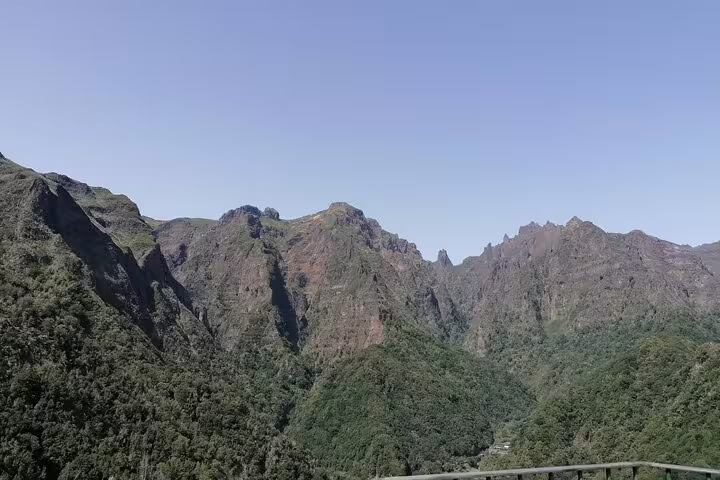 Majestic rugged peaks and verdant valleys under a clear sky in Ribeiro Frio, highlighting scenic mountain tours.