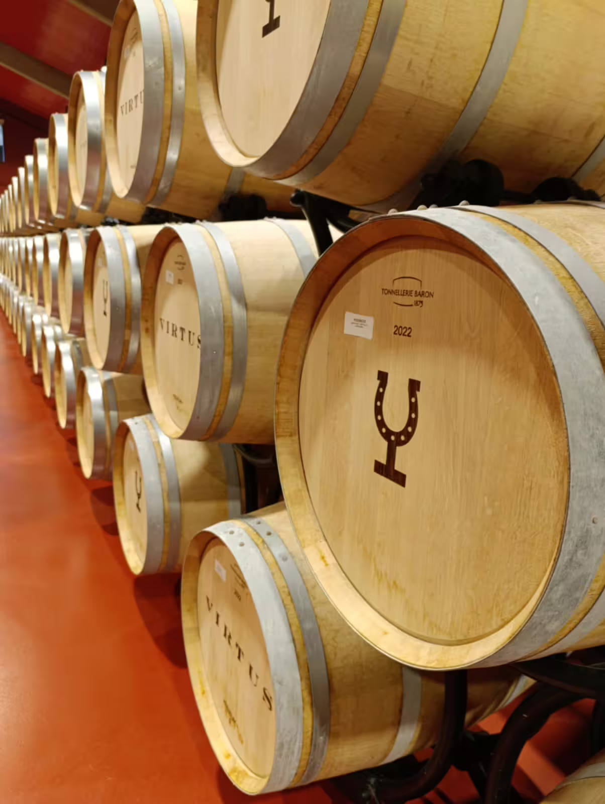 Row of oak barrels in Ribera del Duero winery, showcasing wine production and storage in a modern cellar.