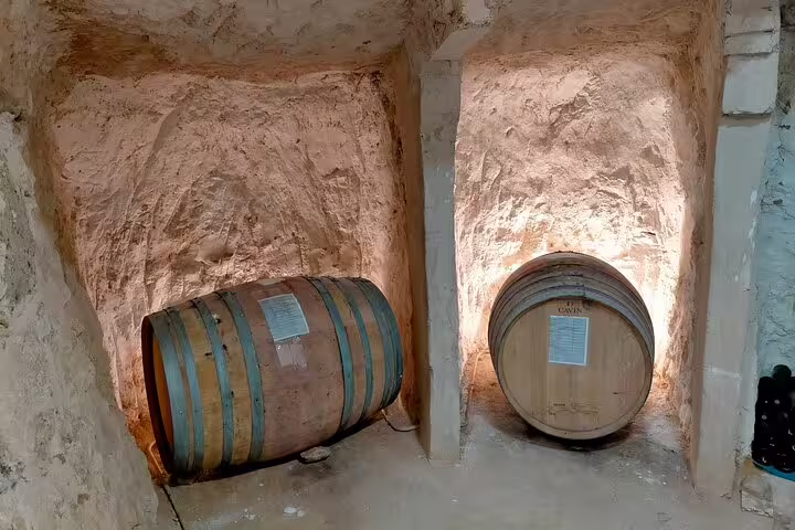 Traditional wine barrels aging in a rustic Ribera del Duero cellar, highlighting authentic Spanish winemaking.
