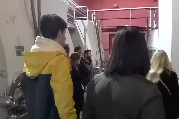Tour group explores Ribera del Duero winery production area with large fermentation tanks on a guided tour.