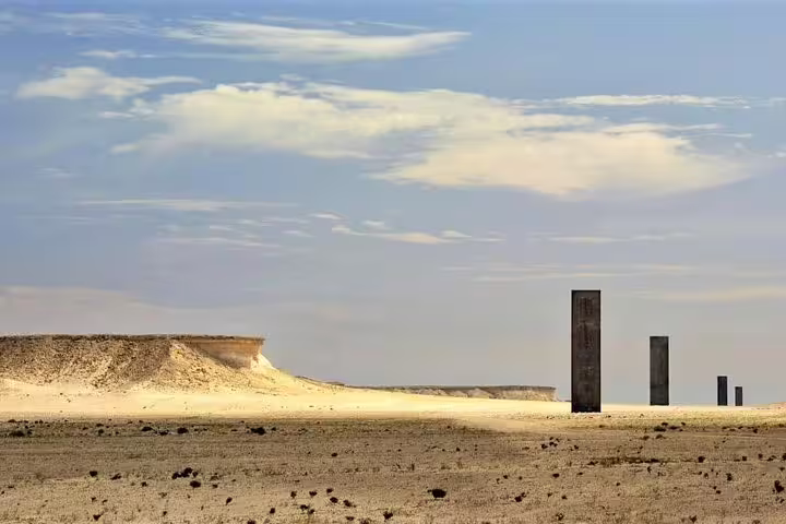 Witness the stunning Richard Serra sculpture amidst the vast desert expanse in Zekreet on a West Coast tour.