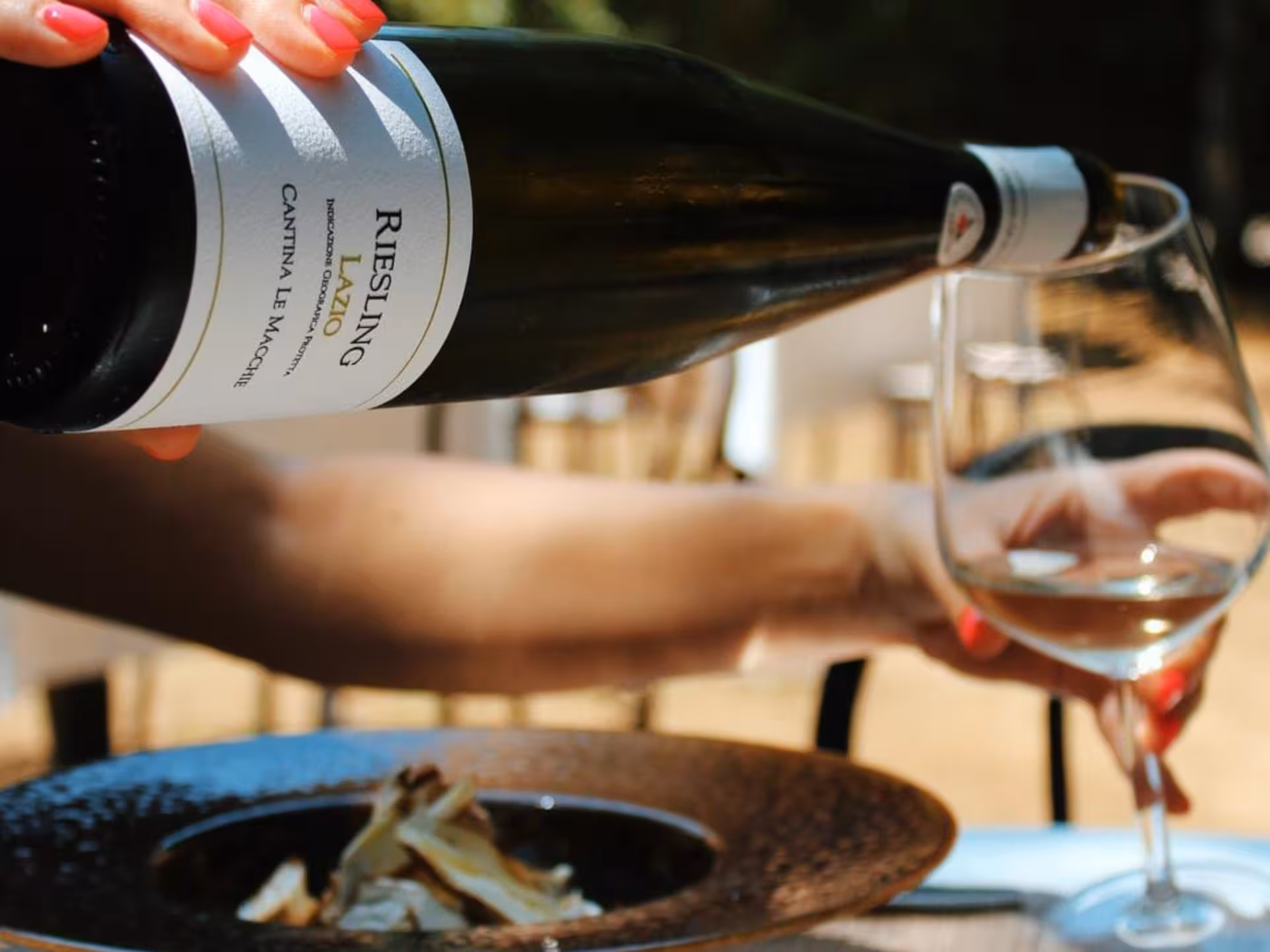 Pouring Riesling wine into a glass during an elegant Rieti countryside tasting experience.