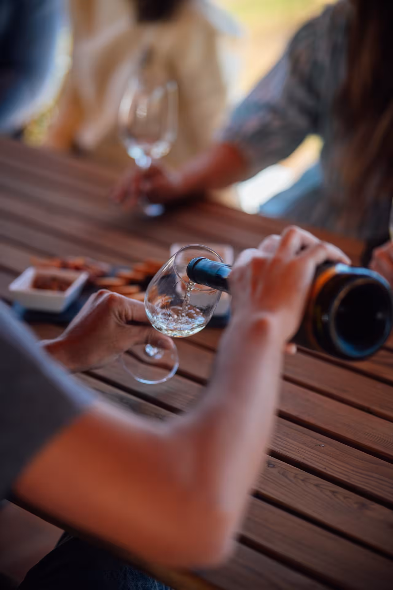 Close-up pouring white wine into glass at Paxá vineyard table during Rihla Paxá - Visit & Try tasting
