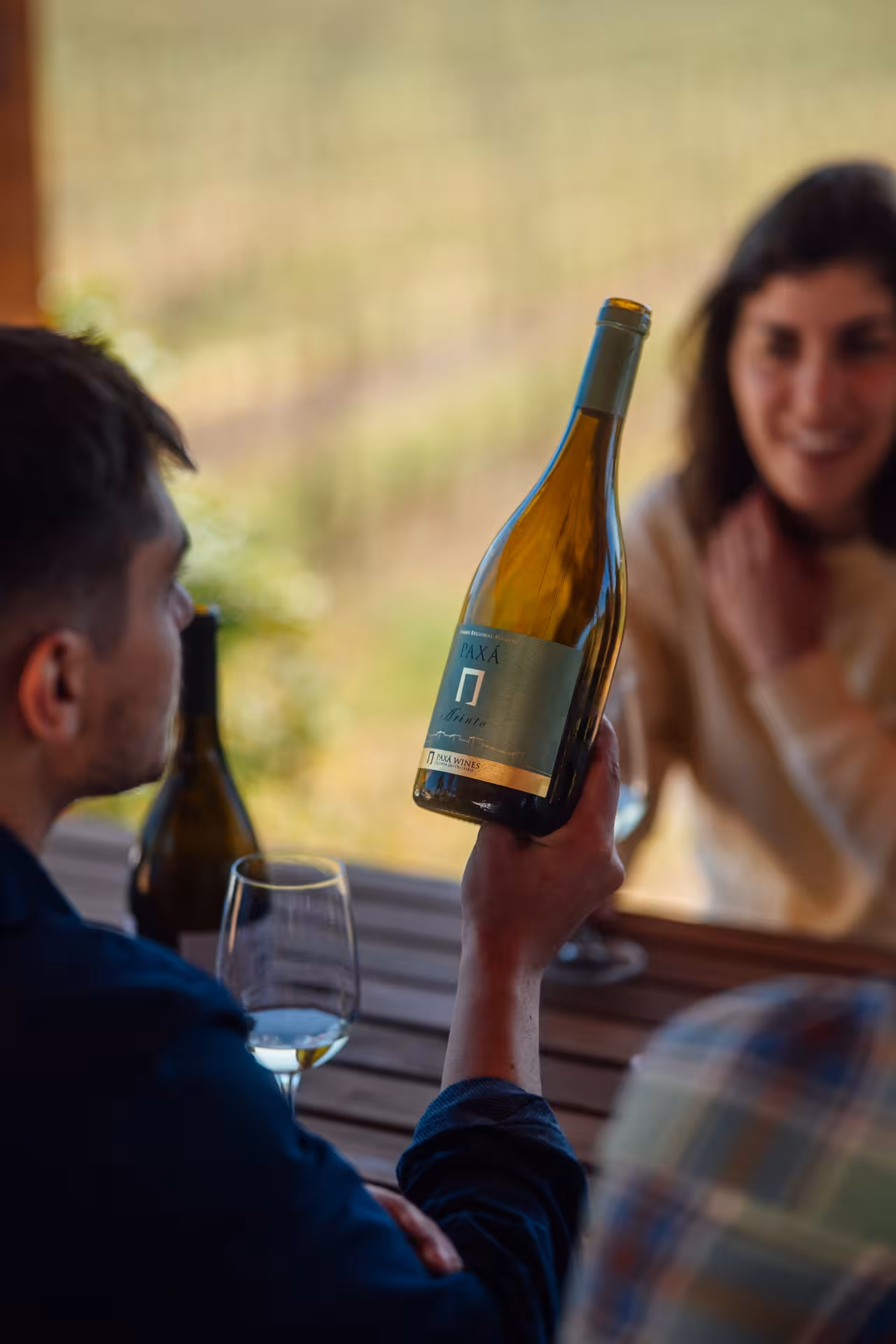 Guest holding Paxá wine bottle during Rihla Paxá Visit & Try vineyard tasting experience with friends