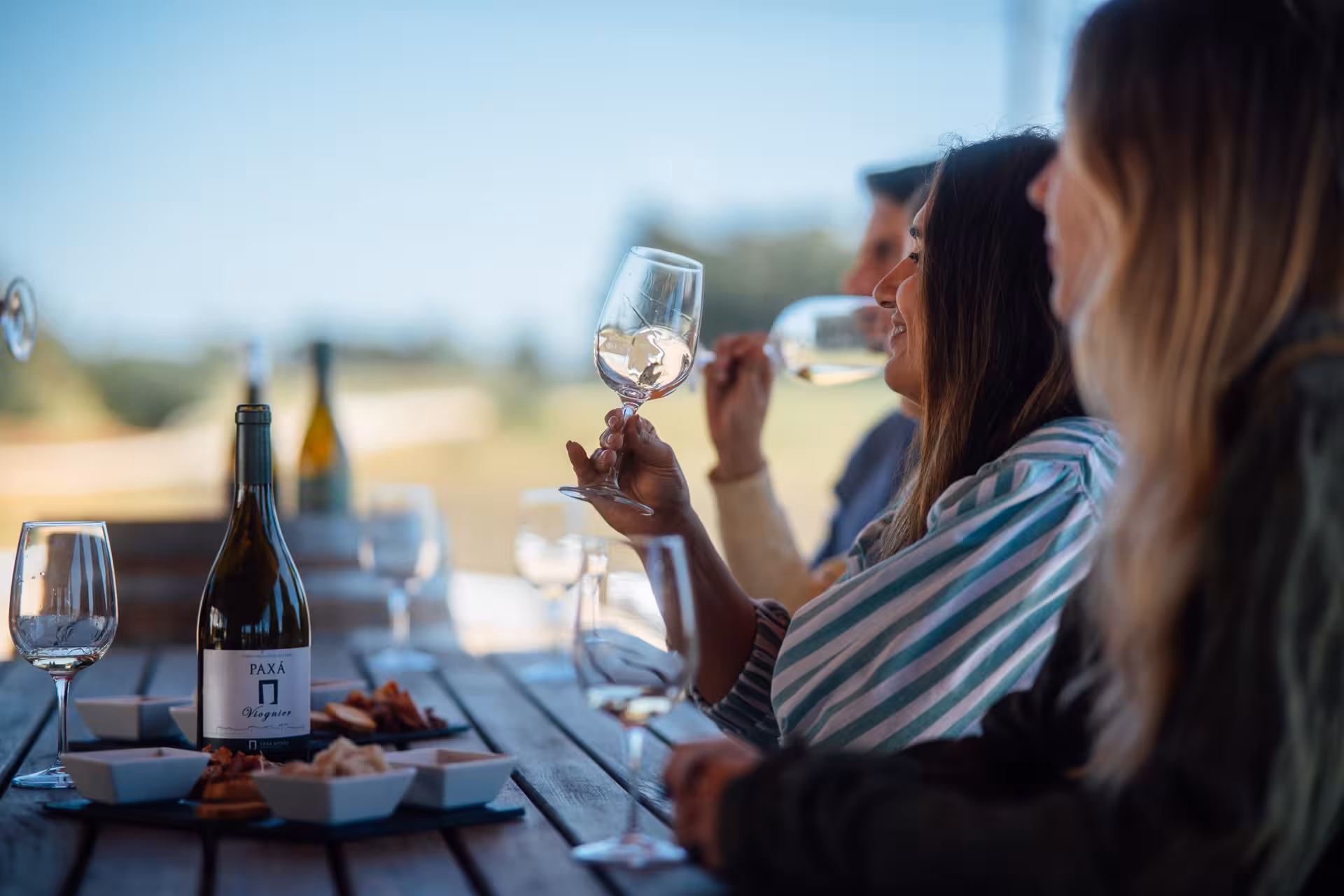 Guests enjoy Paxá winery outdoor wine tasting with local snacks, part of Rihla Paxá - Visit & Try tour