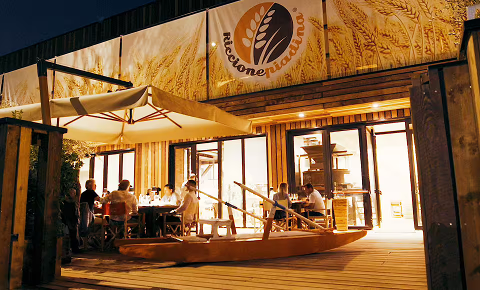 Evening exterior of Rimini Piadina Museum with terrace dining, a must-visit Romagna street food tour stop