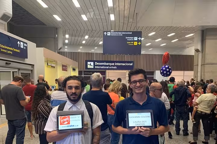 Arrival area at Rio de Janeiro airport with private shuttle drivers holding signs for passengers heading to Buzios.
