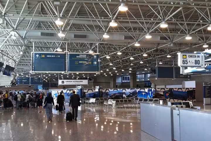 Interior of a bustling Rio de Janeiro airport terminal, showcasing check-in counters and modern travel facilities.