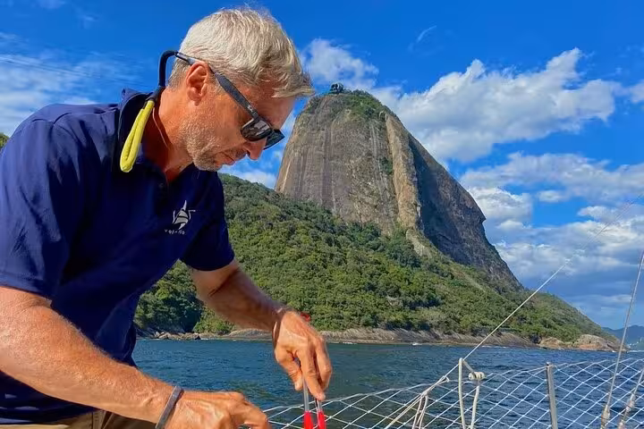 Crew preparing BBQ on a private Rio de Janeiro catamaran tour with open bar, sailing near Sugarloaf Mountain