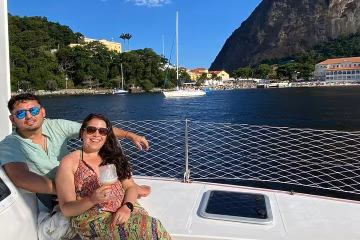 Couple enjoying open bar drinks on private Rio catamaran tour with Sugarloaf Mountain and bay views