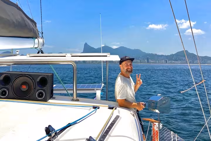 Guest enjoying Rio catamaran cruise with open bar and BBQ, sailing past Sugarloaf Mountain on Velas do Rio