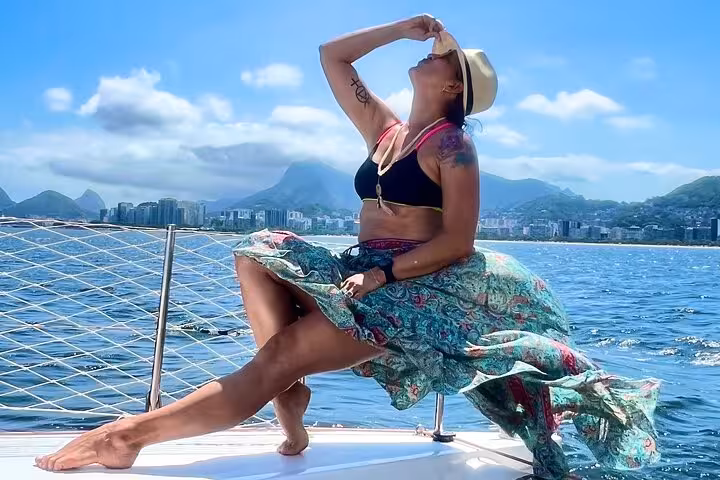 Woman relaxing on Rio de Janeiro catamaran deck with city skyline views on Velas do Rio sailboat tour