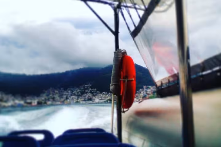 Speedboat journey to Ilha Grande with scenic coastal views from Rio de Janeiro under cloudy skies.