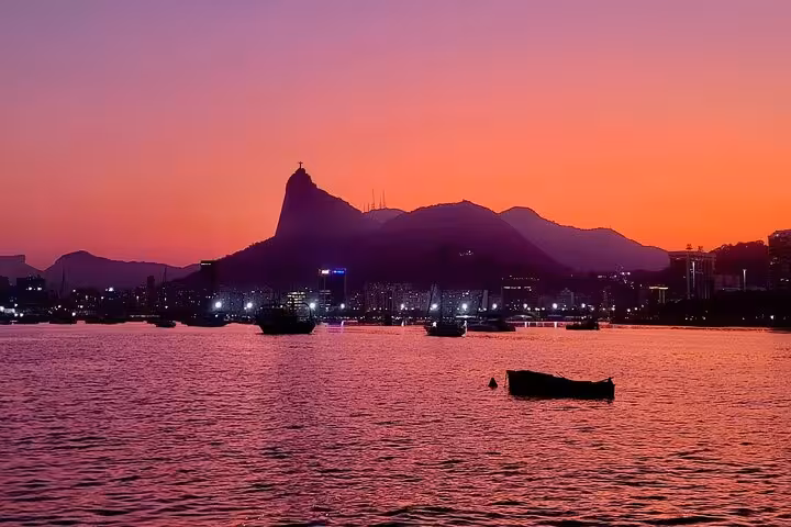 Sunset over Rio de Janeiro bay with boats and mountain skyline on Velas do Rio catamaran sailing tour