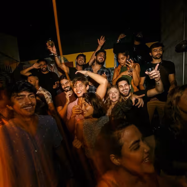 Diverse crowd enjoying a vibrant party atmosphere during a Rio gay nightlife experience with samba music.