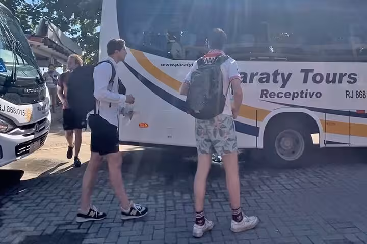 Passengers wearing masks exit a shared shuttle in Rio de Janeiro on their way to Angra dos Reis, enjoying a safe transfer.