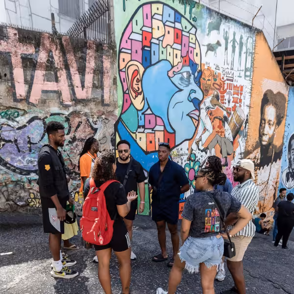 Group of tourists exploring colorful street art murals in Rio's Little Africa on a guided walking tour.