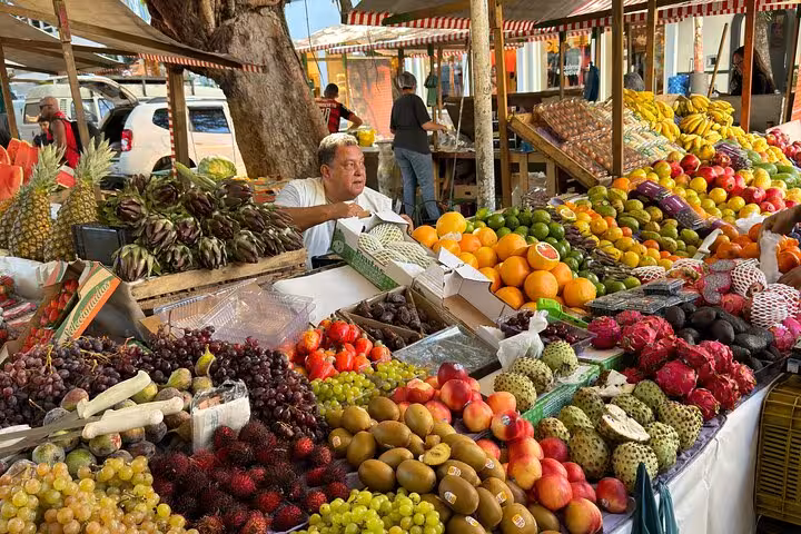 Vibrant Rio market stall brimming with tropical fruits like oranges, bananas, and exotic varieties for tasting tour.