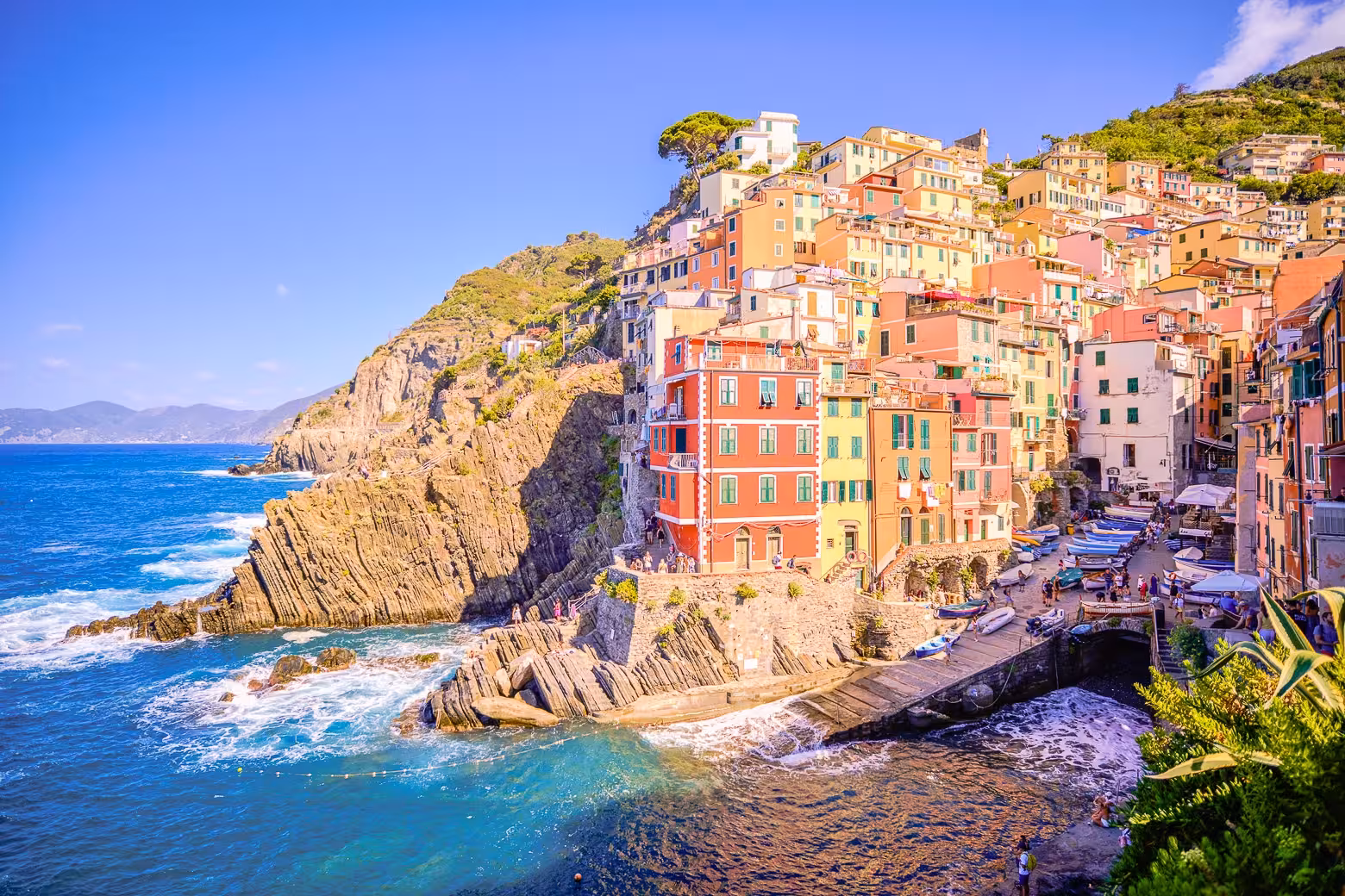Colorful cliffside village of Riomaggiore in Cinque Terre, overlooking the vibrant Mediterranean Sea.