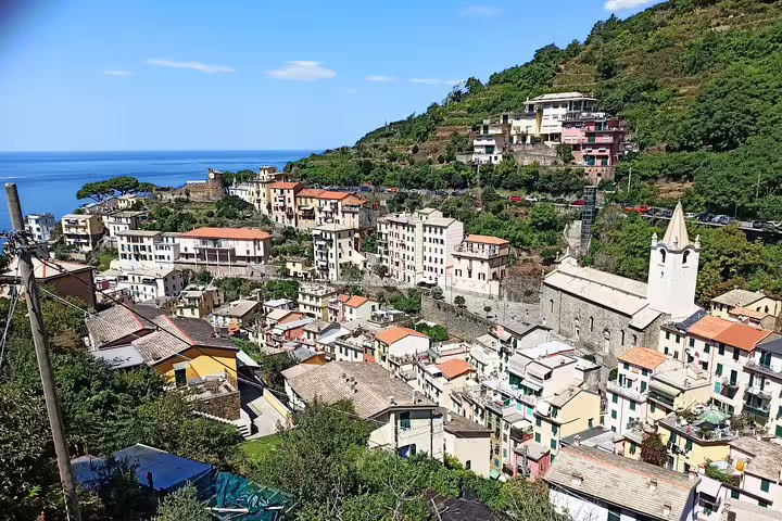Panoramic view of Riomaggiore village and church on a private Cinque Terre day tour overlooking the Ligurian Sea