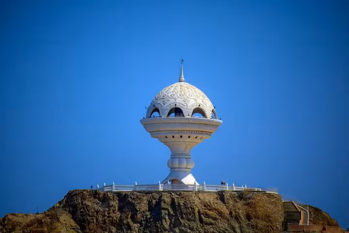 Iconic Riyam incense burner monument on rocky hilltop under clear blue sky, a highlight of classic Muscat private cab tours
