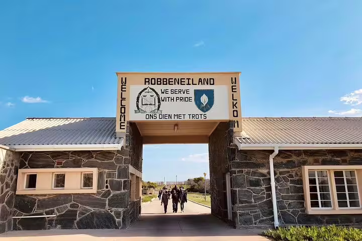 Entrance to Robben Island with welcoming sign, showcasing cultural heritage on a sunny day.