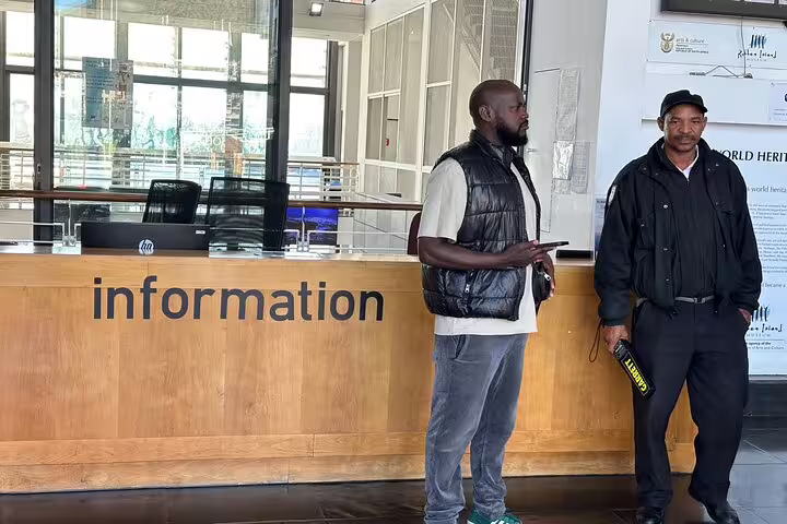 Robben Island visitor center information desk with two staff members ready to assist tourists.
