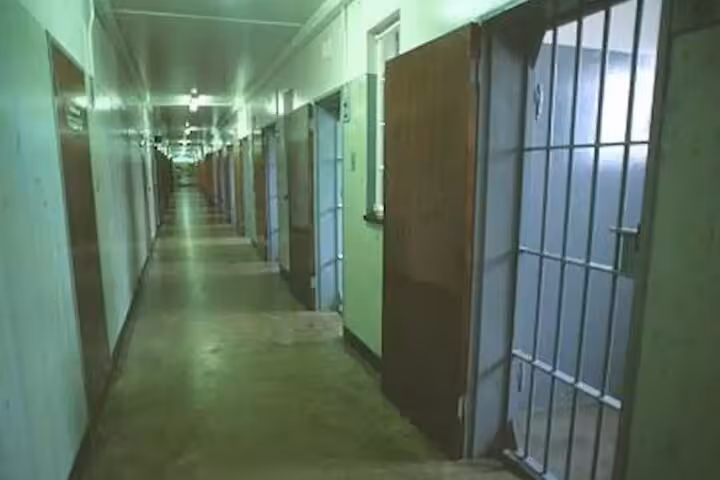 Corridor of prison cells on Robben Island, showcasing historical significance on Cape Town tour.