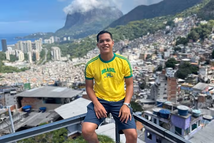 Visitor in a Brazil shirt overlooking the expansive Rocinha Favela, enjoying scenic views during a guided tour.
