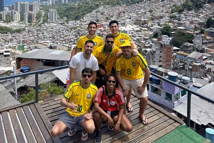 Group of tourists in Brazilian jerseys enjoying a panoramic view of Rocinha favela on a guided tour.