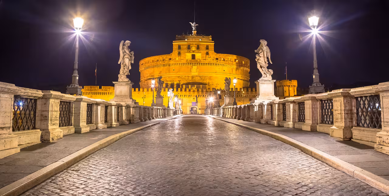 Roma di notte taxi city tour crossing Ponte Sant’Angelo toward Castel Sant’Angelo, Rome skyline glowing under night lights