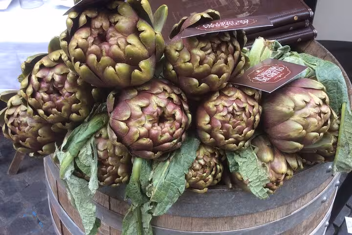 Fresh Roman artichokes displayed in a rustic basket, highlighting traditional Roman cuisine.