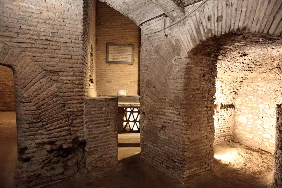 Explore ancient Roman catacombs with brick walls and arched corridors on a guided minivan tour from Rome.