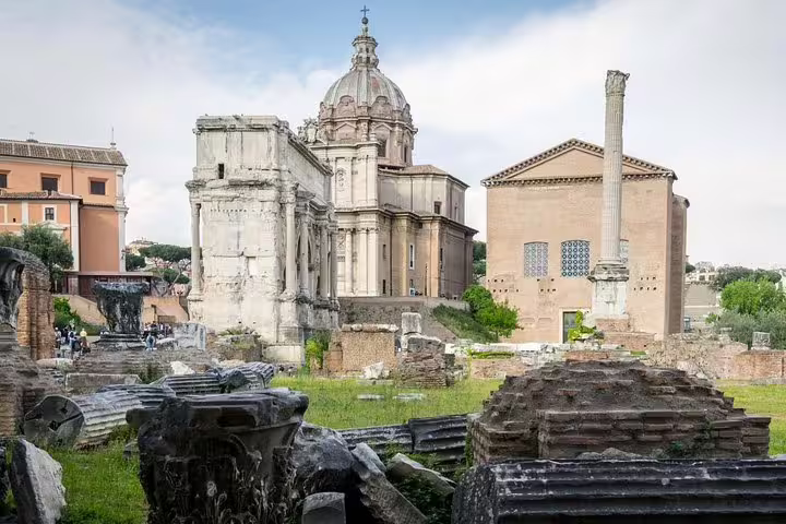 Scattered ruins and historic churches in the Roman Forum archaeological site on a Colosseum and Palatine Hill guided tour