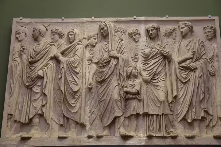 Ancient Roman marble relief of robed figures displayed in the Uffizi Gallery, seen on a guided small group Florence tour
