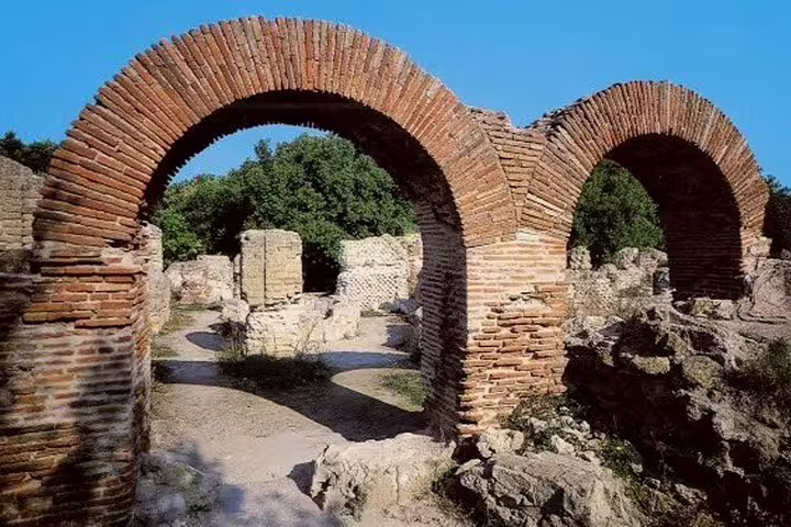 Brick arches and sunlit Roman ruins in the archaeological park of Cuma on a private Phlegraean Fields tour from Naples