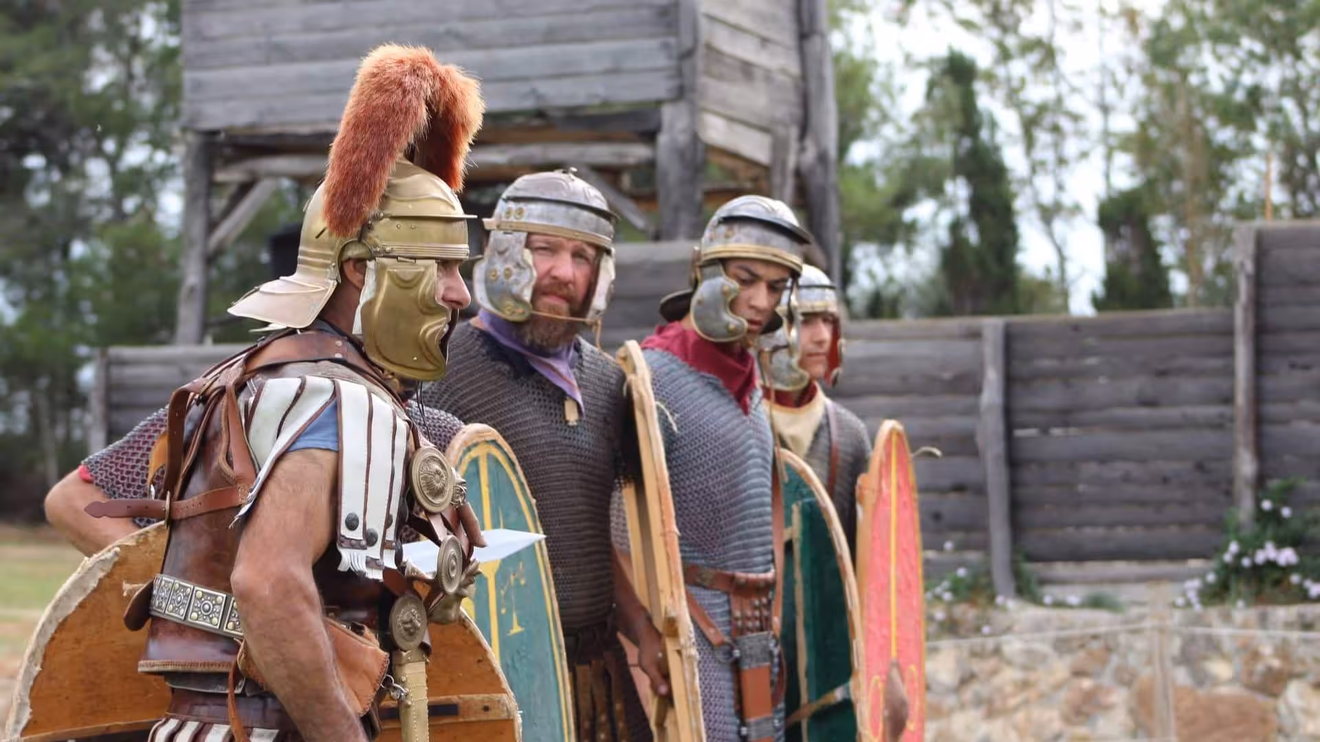 Roman soldiers in full armor stand ready at a reconstructed Castrum, offering an immersive experience in Sassari.